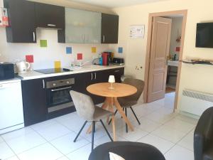 a kitchen with a small table and chairs in it at Le Refuge Salin in Batz-sur-Mer