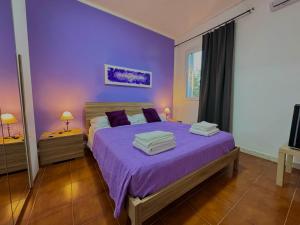 a bedroom with purple walls and a bed with purple sheets at La Nuova Rinascita in San Giovanni Suergiu