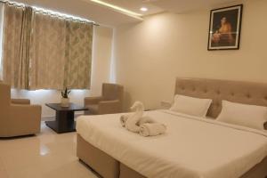 a bedroom with a bed with a towel animal on it at Hotel Surya Teja Priime in Khammam