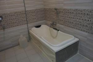 a bath tub in a bathroom with a shower at Hotel Surya Teja Priime in Khammam