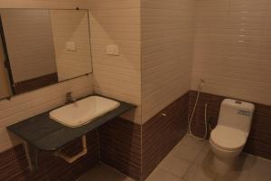 a bathroom with a sink and a toilet at Hotel Surya Teja Priime in Khammam
