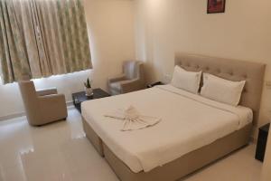 a bedroom with a bed with a dress on it at Hotel Surya Teja Priime in Khammam