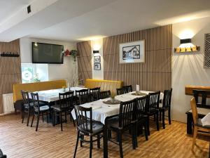 a dining room with tables and chairs and a television at Restaurace a penzion Na Stráni in Klášterec nad Orlicí +30 photos