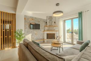 a living room with a couch and a stone fireplace at Sofia's Villa in Riglia