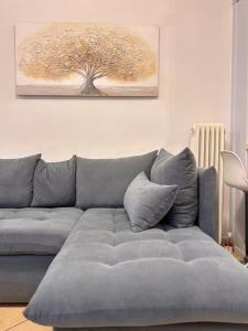 un divano grigio in un soggiorno con un albero di Ampolis Guest House ad Aráchova