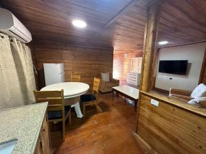 a kitchen and living room with a table and a tv at carmel cabins suite 4 in ‘Isfiyā