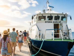people boarding a boat at a dock at Klintehamn Rooms - Near the Sea in Klintehamn