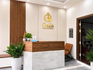 a lobby with a gold sign on the wall at Gabi Boutique Hotel in Mộc Châu