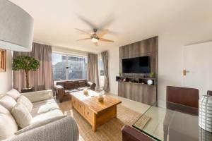 a living room with a couch and a table at Comfy Central with Balcony and Views in Cape Town