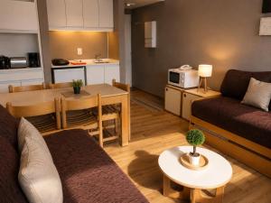 a living room with a couch and a table at Departamento Boutique Las Leñas ATENAS in Las Lenas