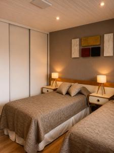 a bedroom with two beds and two lamps at Departamento Boutique Las Leñas ATENAS in Las Lenas