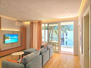 a living room with a couch and a tv at White Shell Apartments in Lalzit Bay