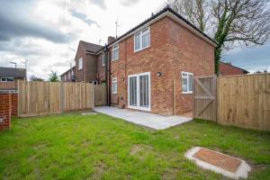 a brick house with a wooden fence in a yard at North Horsham House in Horsham