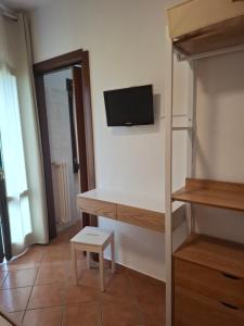 a room with a tv on the wall and a shelf at Cascina Volpi in Montegrino Valtravaglia