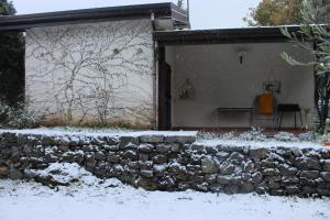 una pared de piedra frente a una casa en la nieve en La casa del Cavaliere, en Santa Maria di Licodia