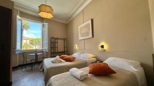 a hotel room with two beds and a window at Hotel Fernanda in Rapallo
