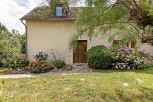 a small house with flowers in front of it at Gîte La Loge in Saint-Aignan