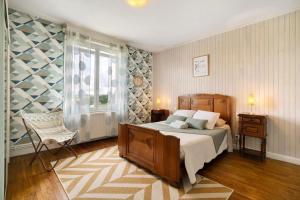 a bedroom with a bed and a chair and a window at Maison de vacances La Couade in Troche