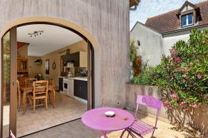 a patio with a purple table and chairs and a kitchen at Gîte La Loge in Saint-Aignan