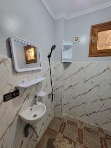 a bathroom with a sink and a mirror on the wall at Villa RAHA villa entière in El Aggada +13 photos