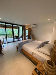 a bedroom with a large bed and glass walls at Bali View Ubud Hotel in Ubud