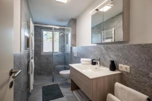 a bathroom with a sink and a toilet and a shower at Ferienwohnungen Roko in Schlitters