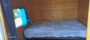 a bed in a wooden room with a window at Suvikoti in Lokalahti +20 photos