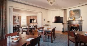 a dining room with tables and chairs and a fireplace at Hotel Kung Carl, WorldHotels Crafted in Stockholm