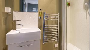 a bathroom with a white sink and a shower at The Granby Hotel in Whitby