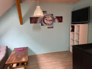 a living room with a table and a clock on the wall at Sternenblick in Neresheim