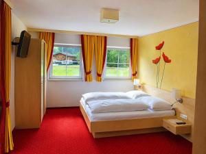 a bedroom with a bed and two windows at Appartement Tauernhof in Kleinarl +34 photos