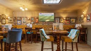 a restaurant with tables and chairs and a television at The Granby Hotel in Whitby +39 photos