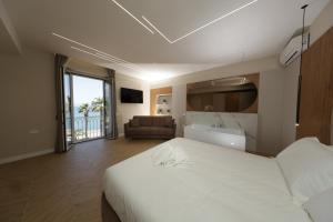 a bedroom with a large white bed and a couch at Live in Gaeta in Gaeta