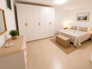 a white bedroom with a bed and a table at Belvedere Apartment in Casa Donato +7 photos