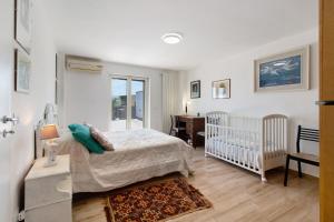 a bedroom with a bed and a crib and a desk at La Mansarda - Terrazze Relax A Due in Cellamare