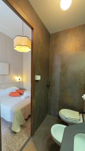 a bedroom with a bed and a bathroom with two toilets at Hotel Fernanda in Rapallo +170 photos