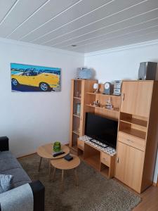 a living room with a yellow car painting on the wall at Dirks Apartment mit Weitblick in Mammelzen +17 photos
