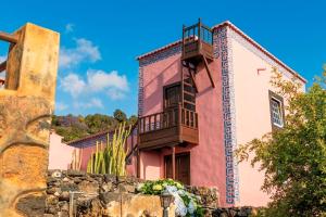 a pink and white building with a balcony at Celeste in Mazo +28 photos