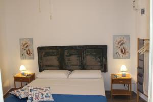 a bedroom with a bed with two lamps on two tables at Casa Briseida in Baia Verde