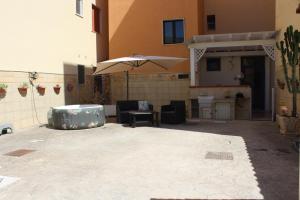 a patio with an umbrella and a table and chairs at Casa Briseida in Baia Verde