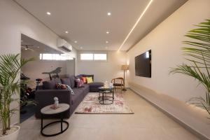 a living room with a couch and a tv at Book Today & save 88 Escape by Spacey Pool-Modern-Prime spot #73- in Cairo