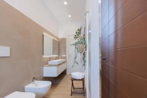 a bathroom with two sinks and a toilet at Dimore Tinè in Castellana Grotte +99 photos