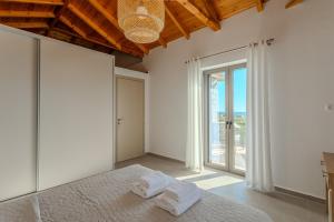 a bedroom with a bed and a large window at Sofia's Villa in Riglia