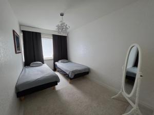 a small room with two beds and a mirror at Apartments at Koulukatu in Savonlinna