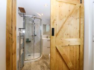 a bathroom with a shower and a sliding barn door at Ty Loti in Caernarfon +14 photos