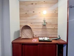 a wooden wall with a table with a book at BRICKS and BLOCKS MIYOTA in Miyota