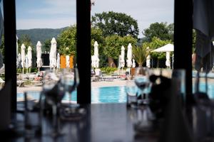 a view of a pool with white umbrellas and chairs at Vrnjačko Vrelo Resort in Novo Selo