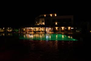 a building with green lights in the water at night at Vrnjačko Vrelo Resort in Novo Selo