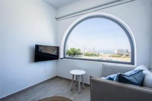 an arched window in a living room with a couch and a table at Naxos Infinity Villa and Suites in Naxos Chora