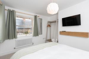 a bedroom with a bed and a flat screen tv at Regent Street Residence Lutterworth in Lutterworth